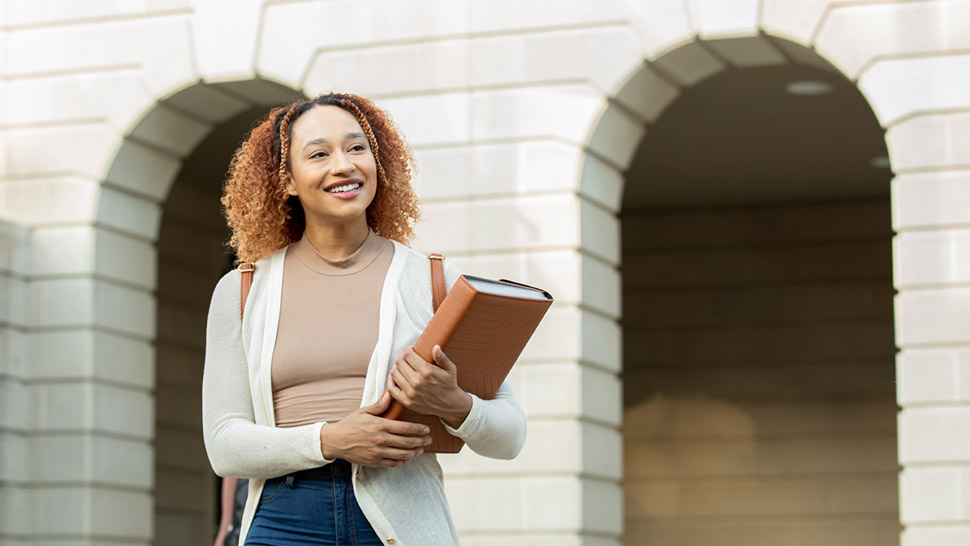 Woman holding a binder while smiling